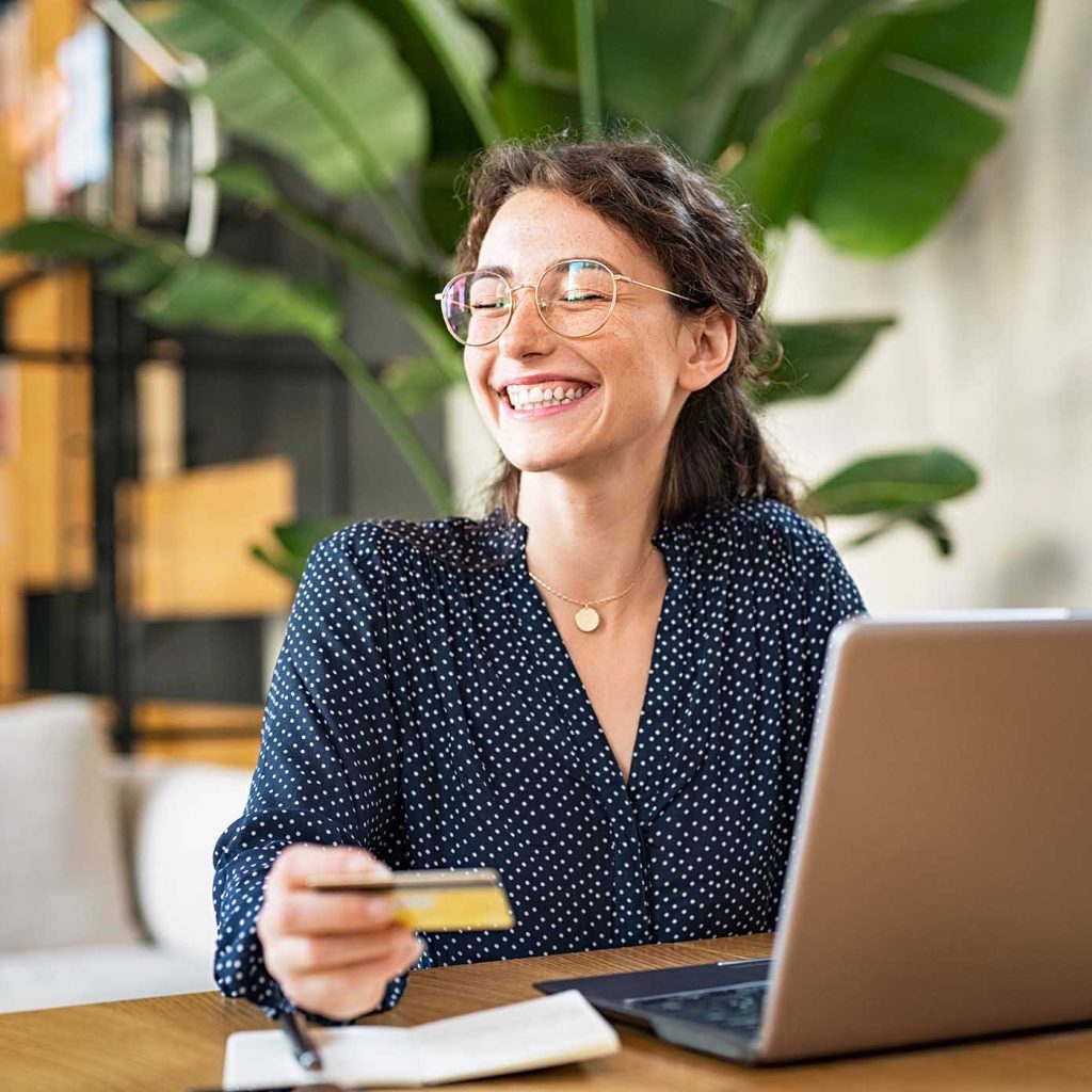 woman-with-laptop-using-credit-card-DZ35VKV.jpg