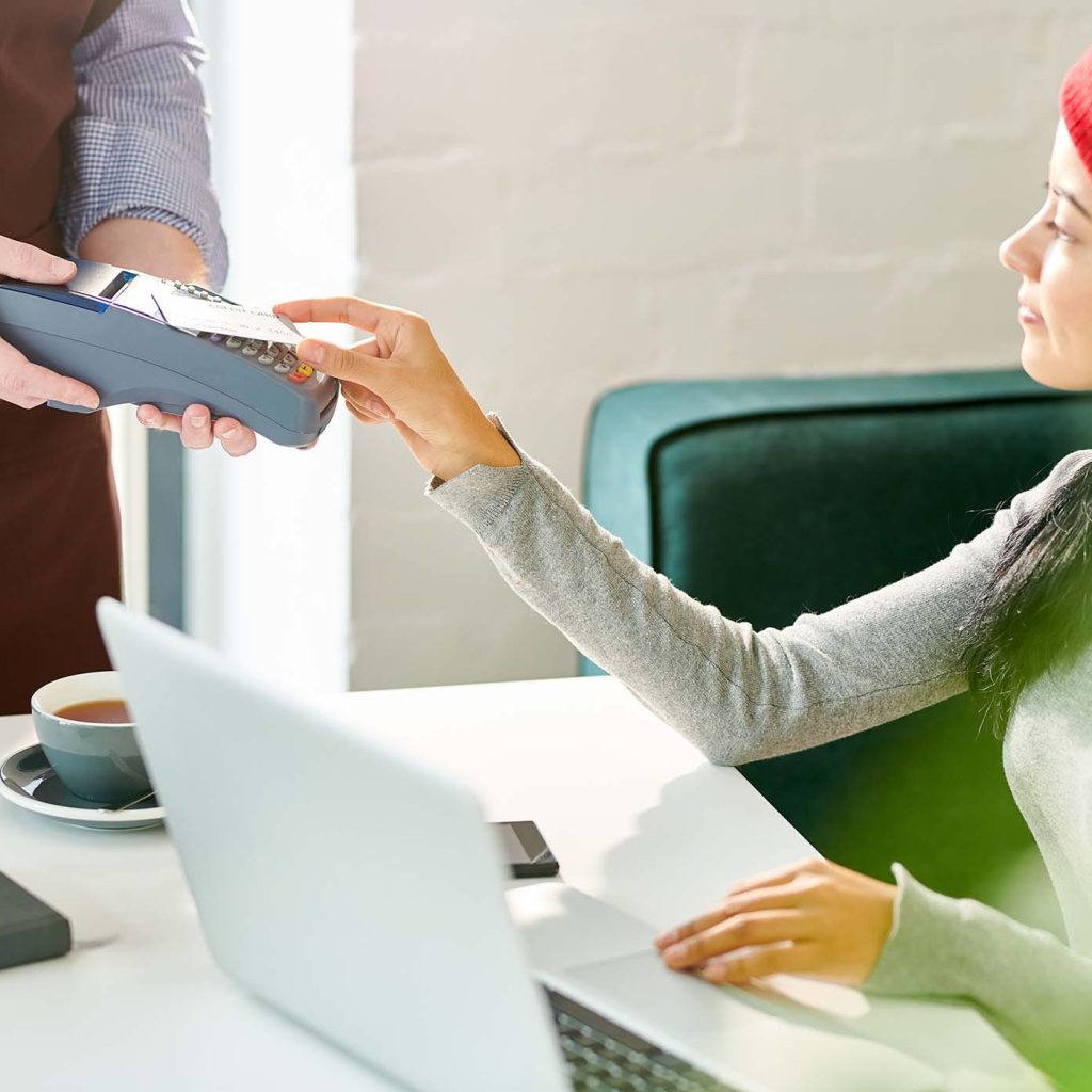 young-woman-paying-by-credit-card-4SUMPWG.jpg